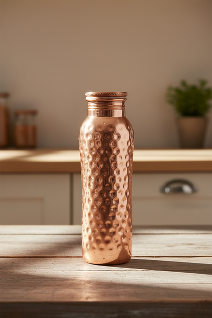 Copper water bottle placed on wooden table in modern kitchen wellness setting